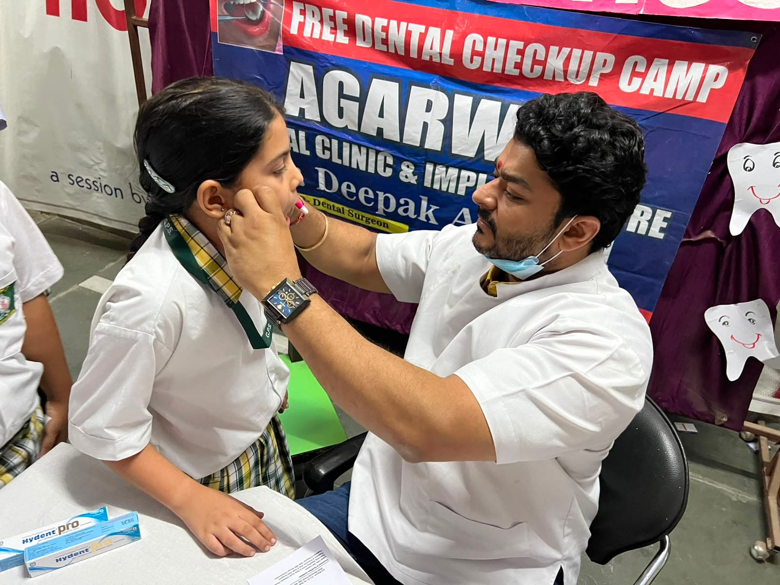 Dr. Deepak Agarwal examining a young patient at dental checkup camp
