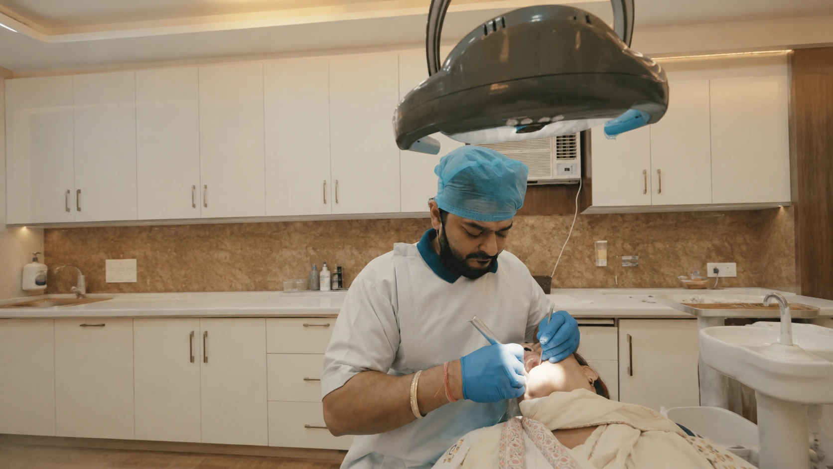 Dr. Deepak Agarwal treating a dental patient chairside at Agarwal Dental Clinic